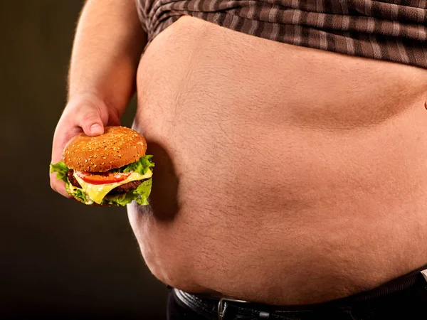 Man belly fat with hamberger fast food . Breakfast overweight person.