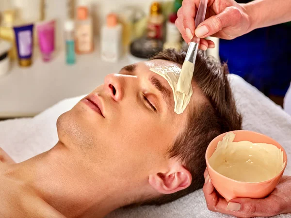 Máscara de barro de curación facial del hombre en el salón de spa . — Foto de Stock