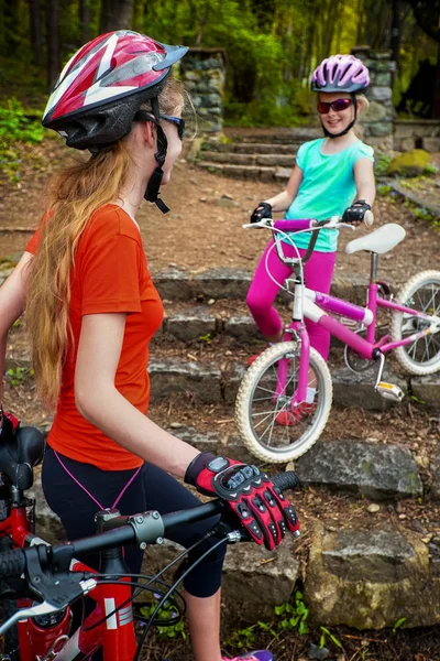 Paseo en bicicleta infantil en carril bici en la ciudad. Los niños bajan escaleras en el parque . — Foto de Stock