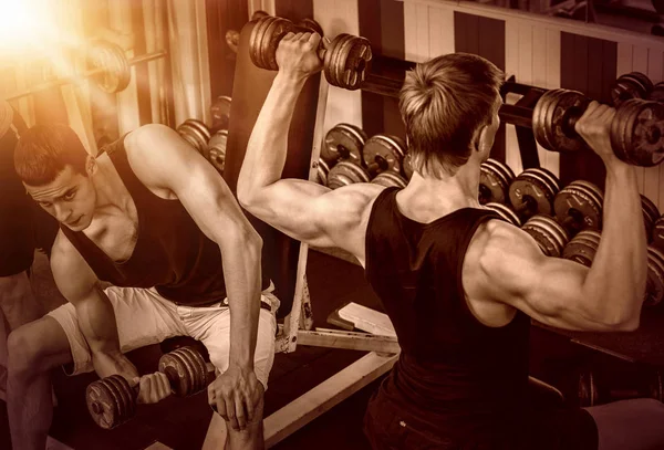 Männer mit Langhantel im Fitnessstudio. Farbton Hintergrund. — Stockfoto