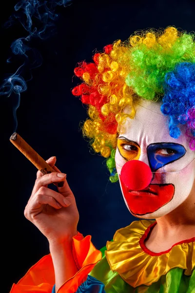 Безумный клоун на черном фоне. Женщина курит сигару . — стоковое фото