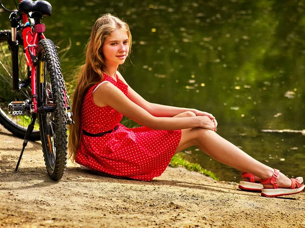 Fahrräder radeln Mädchen in Park. Mädchen sitzt angelehnt auf Fahrrad am Ufer. — Stockfoto