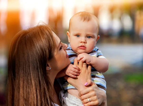 Baby i park utomhus. Kid på mammor händer. — Stockfoto