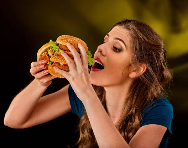 Donna che mangia hamburger. Lo studente consuma fast food sul tavolo . — Foto Stock