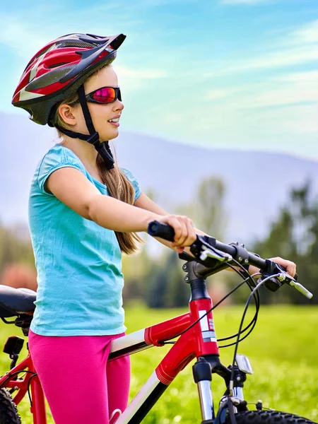 Mujer viajando bicicleta sobre hierba verde en el parque de verano . — Foto de Stock