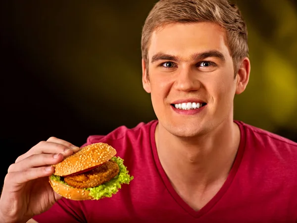 Un uomo che mangia hamburger. Ragazzo morso di hamburger molto grande — Foto Stock