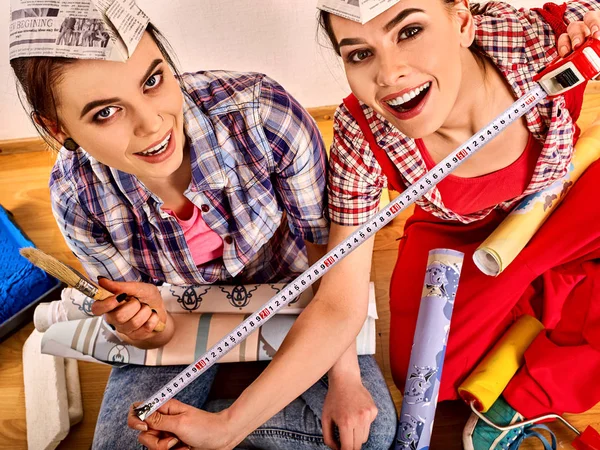 Reparación de las mujeres del hogar celebración de la construcción medición de papel pintado . —  Fotos de Stock