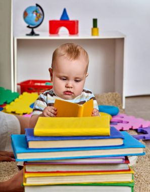 Yerde yatarken erkek bebek çocuk ve kitap okumak.