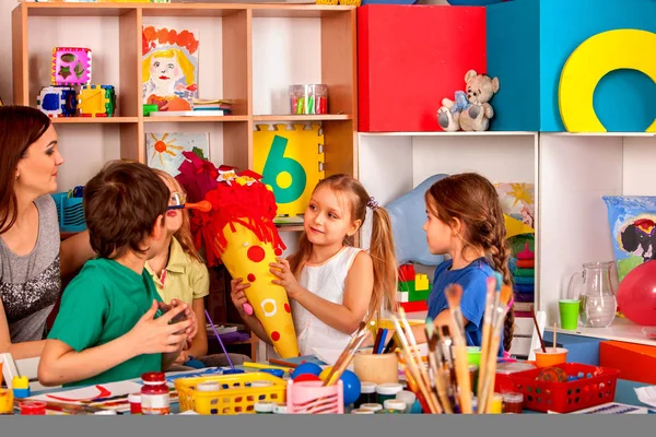 Kind schilderen op tafel. Girl make kegel schultuete snoep. — Stockfoto