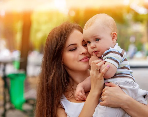 Baby i park utomhus. Kid på mammor händer. — Stockfoto