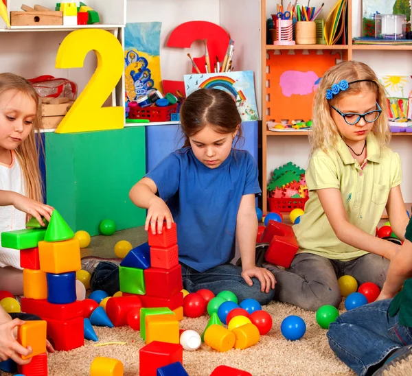 Crianças construindo blocos no jardim de infância. Grupo de crianças jogando chão de brinquedo  . — Fotografia de Stock