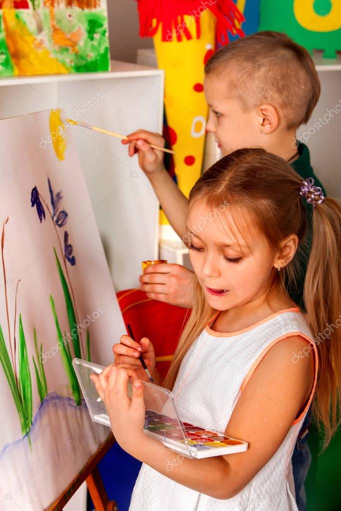 Bambini che dipingono il dito sul cavalletto. Gruppo di bambini