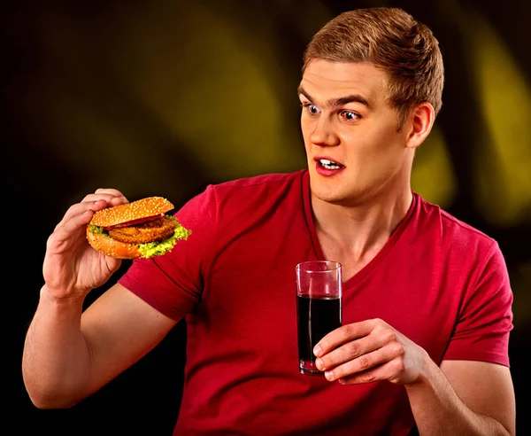 Hombre comiendo papas fritas y hamburguesa . — Foto de Stock