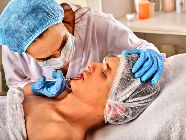 Hautfüllungen des Mannes im Wellness-Salon mit Kosmetikerin. — Stockfoto