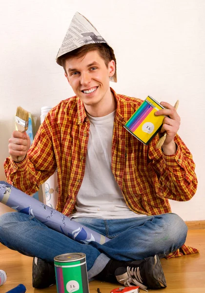 Reparar casa hombre sosteniendo rodillo de pintura para el papel pintado . — Foto de Stock