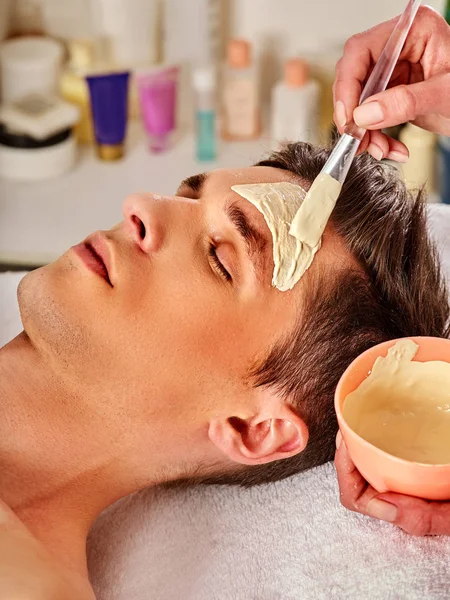 Máscara de barro de curación facial del hombre en el salón de spa . — Foto de Stock