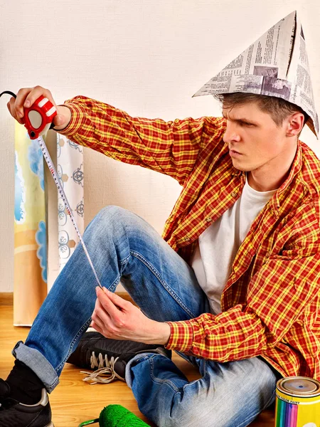 Reparera hem mannen håller paint roller för tapet. — Stockfoto