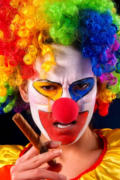 Böser Clown auf schwarzem Hintergrund. Porträt einer rauchenden Frau. — Stockfoto