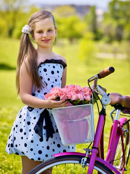 Dziecko dziewczyna sobie białe groszki sukienka przejażdżki rowerowe w parku. — Zdjęcie stockowe