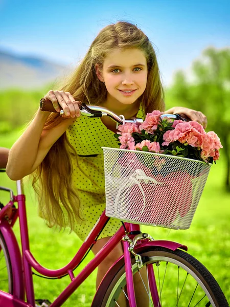 Flickan bär röda prickar klänning Rider cykel i park. — Stockfoto