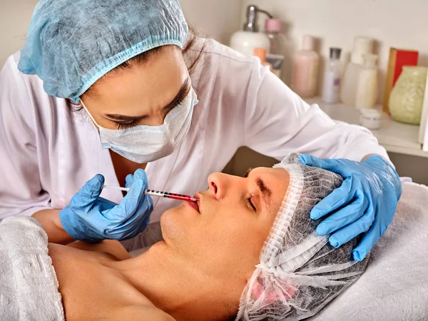 Hautfüllungen des Mannes im Wellness-Salon mit Kosmetikerin. — Stockfoto