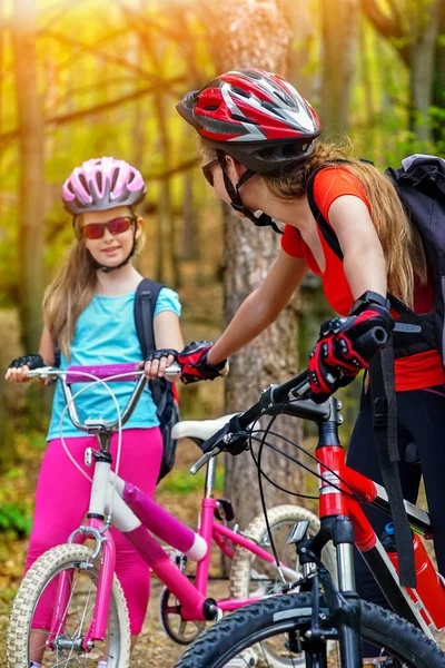 Bicicletas família ciclismo. Mãe e filha usando capacete estão pedalando em bicicletas  . — Fotografia de Stock