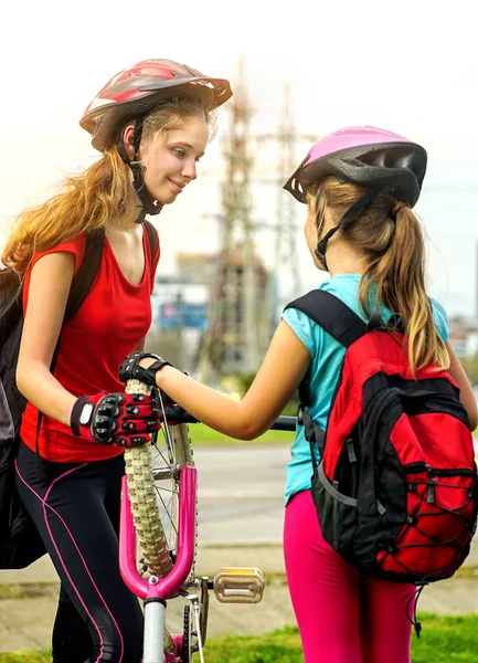 자전거 타이어 어린이 자전거에 의해 펌핑입니다. 소녀 수리 자전거도로에. — 스톡 사진