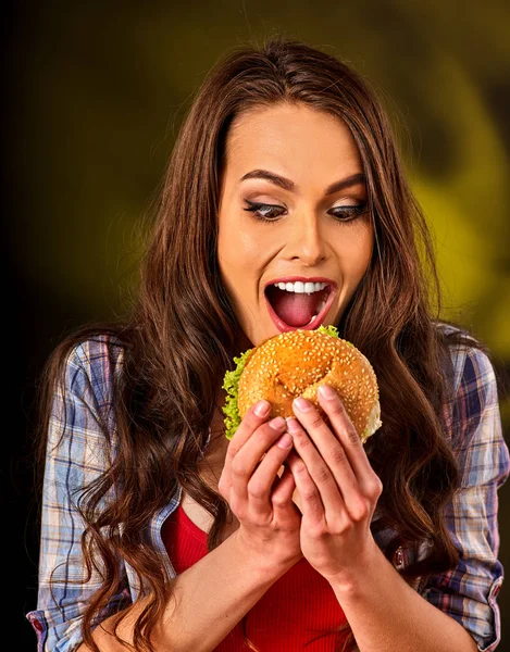 Vrouw eten en hamburger op tafel. — Stockfoto