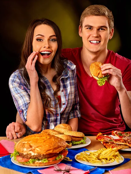 Para, jedzenie fast food. Mężczyzna i kobieta zjeść hamburgera. — Zdjęcie stockowe