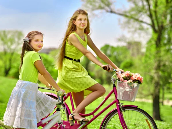 Dziewczyna noszenie czerwony groszki sukienka przejażdżki rowerowe w parku. — Zdjęcie stockowe