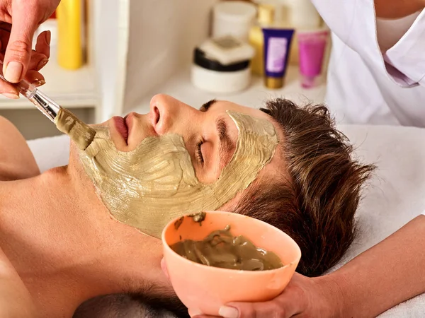 Mud facial mask of man in spa salon. Face massage. — Stock Photo, Image