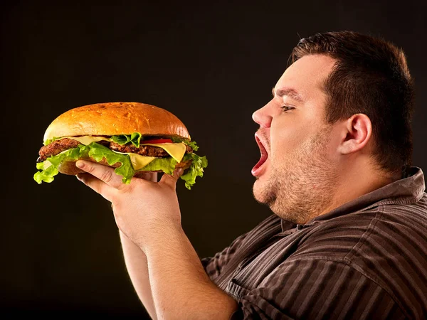 Hombre gordo comiendo hamburguesa de comida rápida. Desayuno para personas con sobrepeso . —  Fotos de Stock