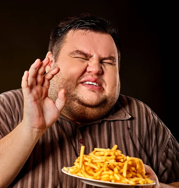 Dikke man eten fastfood frietjes voor overgewicht persoon. — Stockfoto