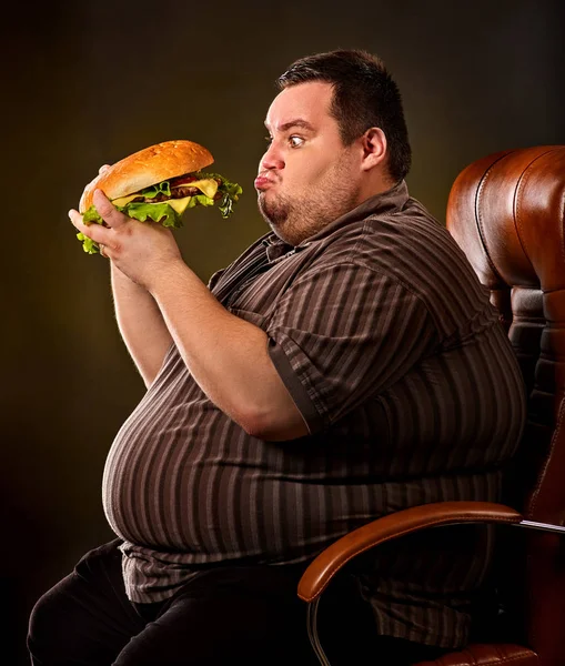 Hombre gordo comiendo hamburguesa de comida rápida. Desayuno para personas con sobrepeso . — Foto de Stock