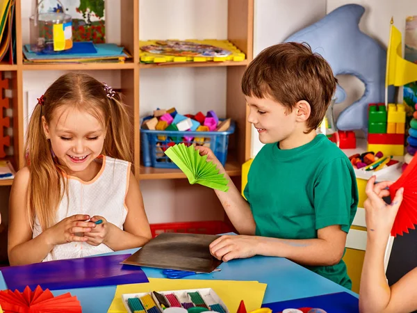 School kinderen met een schaar in handen van de kids snijden van papier . — Stockfoto