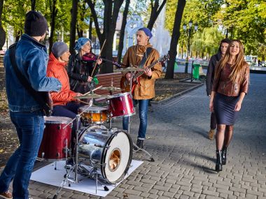 Festival music band. Friends playing on instruments city autumn park. clipart
