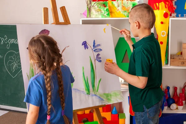 Bambini che dipingono il dito sul cavalletto. Gruppo di bambini con insegnante . — Foto Stock