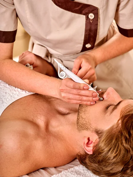 Facial massage at beauty salon. Electric stimulation man skin care. — Stock Photo, Image