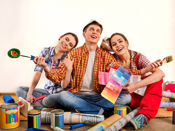 Repair group of people building home using paint roller tools.