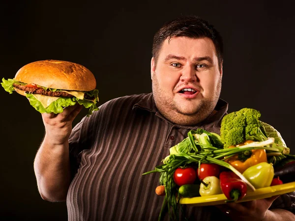 Diätfetter Mann trifft Entscheidung zwischen gesunder und ungesunder Ernährung. — Stockfoto