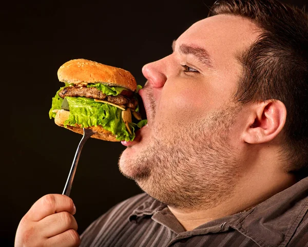 Fet man äter snabbmat hamberger. Frukost för överviktig person. — Stockfoto
