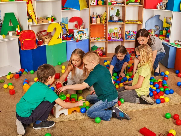 Crianças construindo blocos no jardim de infância. Grupo de crianças jogando chão de brinquedo  . — Fotografia de Stock