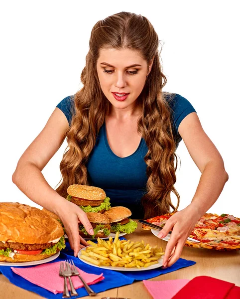 Woman eating french fries and hamburger. — Stock Photo, Image