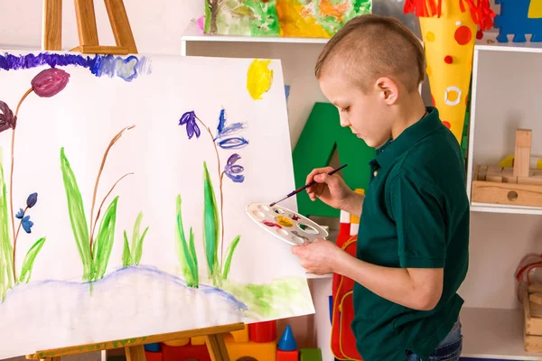 Dedo de pintura infantil no cavalete. Kid boy aprender pintura escola . — Fotografia de Stock
