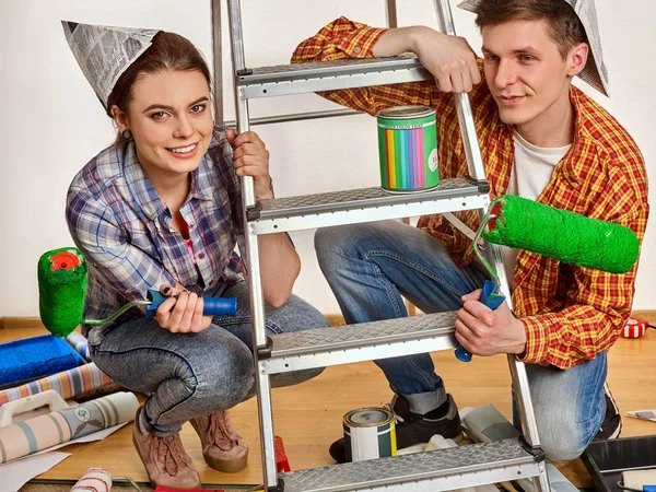 Reparera familj av lyckliga par byggnad hem med hjälp av stege. — Stockfoto