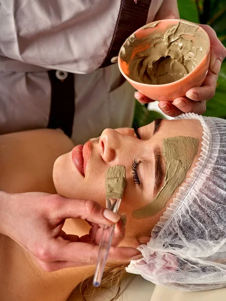 Mud facial mask of woman in spa salon. Face massage . — Stock Photo, Image