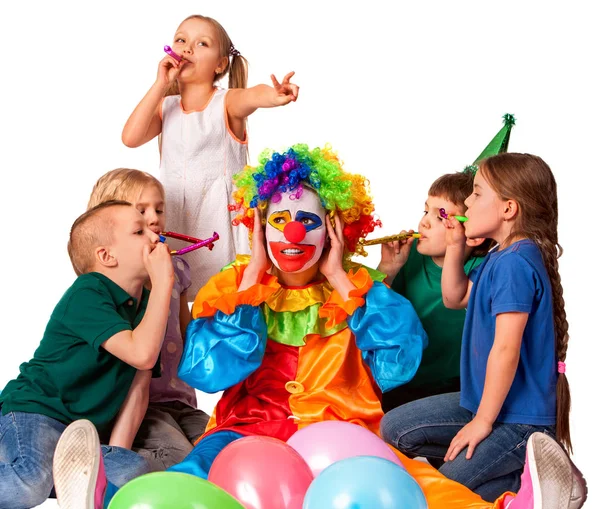 Payaso de cumpleaños cerca de las orejas de los niños ruido con los niños del grupo . — Foto de Stock