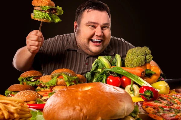 Dieta homem gordo faz escolha entre alimentos saudáveis e não saudáveis . — Fotografia de Stock
