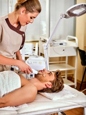 Yüksek frekans makine Spa. Adam darsonval yüz masajı alma.