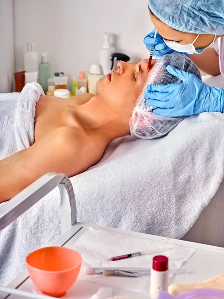 Hautfüllungen des Mannes im Wellness-Salon mit Kosmetikerin. — Stockfoto